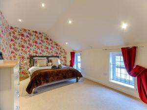 a bedroom with a bed and a red wall at 2 bed property in Llandysul 77655 in Llangynllo