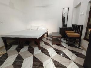 Cette chambre comprend un lit, une chaise et une table. dans l'établissement Hotel Basant Palace, à Fatehpur Sīkri