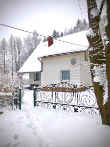 a house with a gate in the snow at Domek w Glince in Ujsoły
