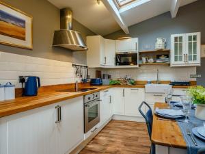 a kitchen with white cabinets and a wooden table at 2 Bed in Leominster 78637 in Stoke Prior