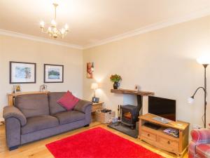 a living room with a couch and a television at 4 Bed in Brodick CA381 in Brodick