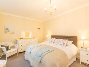 a bedroom with a bed and a chair and a dresser at 4 Bed in Brodick CA381 in Brodick