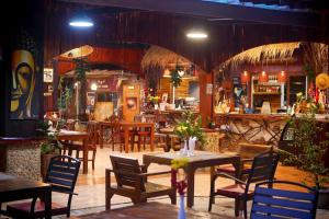 a restaurant with tables and chairs and a bar at Big Elk Steak House - HomeStay in Trat