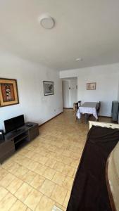 ein Wohnzimmer mit einem TV und einem Tisch in der Unterkunft Check and Home - Rawson - 4 huéspedes amplio en el centro in Mar del Plata