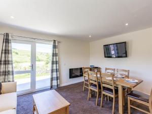 een woonkamer met een tafel en stoelen en een televisie bij 3 bed in Moffat CA402 in Moffat