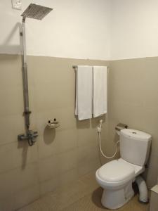 a bathroom with a toilet and a shower and towels at Hotel Sapid Luck Yala Safari in Tissamaharama