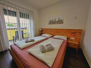 1 dormitorio con 2 camas y ventana grande en Gold Apartmani Kozarac, en Kozarac