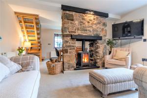 a living room with a stone fireplace at The Crossing Cottage in Pwllheli