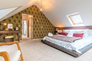 a bedroom with a large bed with red pillows at The Crossing Cottage in Pwllheli