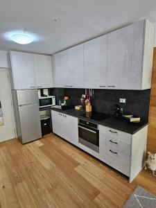 una cucina con armadietti bianchi e pavimenti in legno di Bella vista a Limone Piemonte