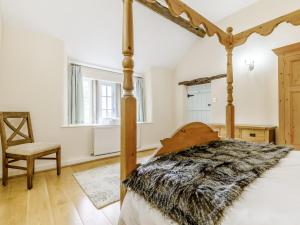 a bedroom with a four poster bed and a chair at 3 Bed in Wetton 79554 in Wetton