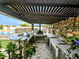 una cocina al aire libre con una pared de piedra en Casa Zahora, en Zahora