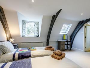 a bedroom with two beds and two windows at 3 Bed in Osmington 80374 in Broadmayne