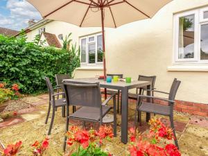 a table and chairs with an umbrella on a patio at 3 bed in Glasbury-on-Wye BN289 in Glasbury