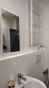 ein weißes Badezimmer mit einem Waschbecken und einem Spiegel in der Unterkunft Pane e Tulipani, cozy apartment near city center in Turin