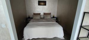 1 dormitorio con 1 cama con sábanas y almohadas blancas en Апартаменты в ЖК " 30я Жемчужина KADORR" en Liski