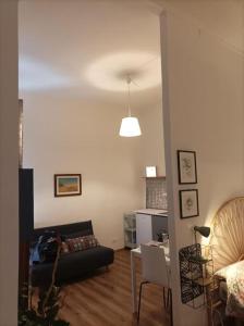 ein Wohnzimmer mit einem Sofa und einem Tisch in der Unterkunft Pane e Tulipani, cozy apartment near city center in Turin