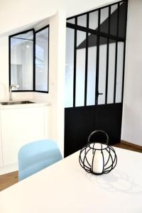 uma cozinha com uma mesa branca e uma cadeira azul em Margarita Apt Climatisé T2 4 pers Centre parking em Le Touquet-Paris-Plage