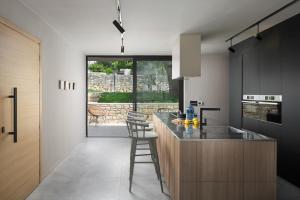 a kitchen with a counter with a sink and chairs at Modern Villa Melon with outdoor pool in Porec in Krmenjak