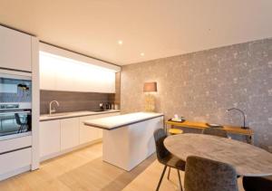 a kitchen with a table and a counter top at Acropolis - Luxury Appartments I Hotelservice and FREE parking in Middelkerke