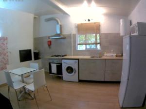 uma cozinha com um fogão, um lavatório e uma mesa em Quinta da Ponte das Hortas 1 em Elvas
