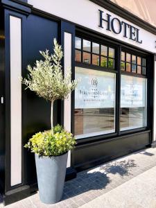 a hotel with a potted tree in front of a building at Beresford Hotel in Dublin