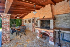 a patio with a brick fireplace and a table and chairs at Rustic Villa Simone with outdoor pool in Porec in Krmenjak