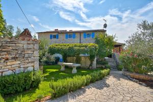 a garden with a bench in front of a house at Rustic Villa Simone with outdoor pool in Porec in Krmenjak