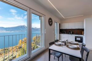 cocina con mesa y sillas y ventana grande en Casa Serena, en Torri del Benaco