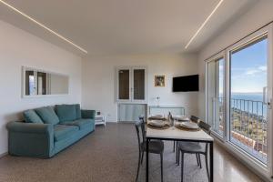 een woonkamer met een blauwe bank en een tafel met stoelen bij Casa Serena in Torri del Benaco