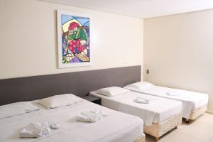 a room with three beds and a painting on the wall at Hotel Aquarius in Fortaleza +63 photos