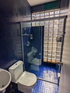 a bathroom with a toilet and a shower and a sink at Cobertura Duplex/Penthouse em Copacabana in Rio de Janeiro