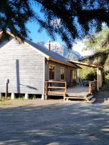 een huis met een houten veranda met een berg bij Refugios de Montaña Reloncaví - Ruka Lee I in Las Trancas
