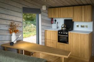 a kitchen with wooden cabinets and a wooden table at Off Grid Travel at Cambo Estate in St Andrews