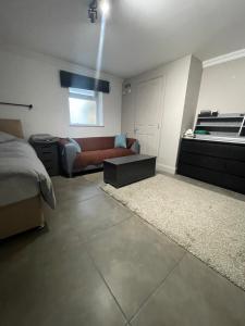 uma sala de estar com uma cama e um sofá em 50A Green Lane em Cranford