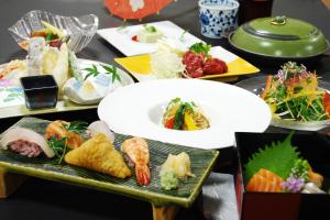 una mesa cubierta con platos de sushi y comida en Wasuki Tsukasakan, en Kumamoto