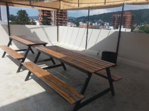 dos bancos de madera sentados en la parte superior de un techo en DEPARTAMENTO EN CARLOS PAZ en Villa Carlos Paz
