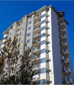 a tall white apartment building with balconies at Garden estate Thika road furnished home in Nairobi