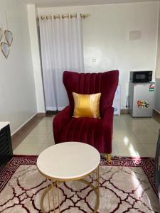 a living room with a red couch and a table at Garden estate Thika road furnished home in Nairobi