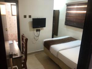 a bedroom with a bed and a tv on the wall at Roban Hotels Limited in Enugu