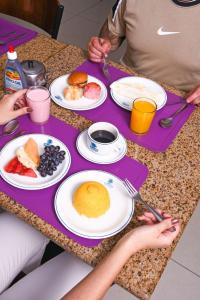 Dos personas sentadas en una mesa con platos de desayuno en Hotel Aquarius en Fortaleza