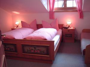 1 dormitorio con 2 camas individuales y almohadas rojas en Naflerhof, en Obertilliach