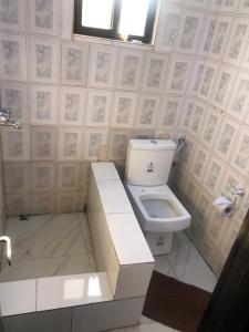a bathroom with a toilet and a sink at Roban Hotels Limited in Enugu