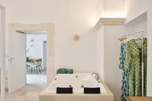 a white bathroom with a tub in a room at Silentio Suite N2-Ostuni-Jacuzzi in Ostuni