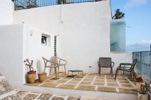 a room with chairs and a table on a balcony at Silentio Suite N2-Ostuni-Jacuzzi in Ostuni