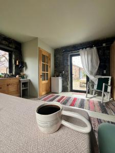 a room with a cup of coffee on a bed at Zove Rural Cottage with garden views in Kʼarashamb