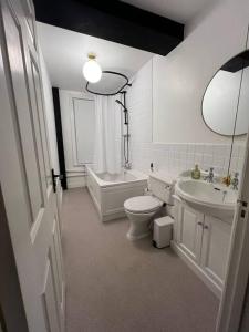 a bathroom with a toilet and a tub and a sink at Friar Loft in Worcester