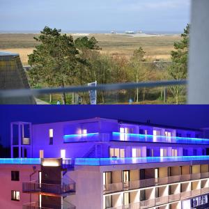 ein lila Gebäude mit blauen Lichtern darüber in der Unterkunft Parkhotel Residenz in Sankt Peter-Ording