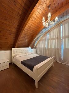 Hotel Noventa في Noventa Vicentina: غرفة نوم بسرير ابيض في سقف خشبي