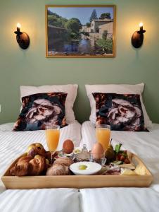 een dienblad met eten op een bed met twee bedden bij Hotel Rêve de la Vallée in Blesle